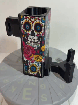 A rotating black Paddle Saver™ with an attached Match Point Muerto skin. The skin has a Day Of The Dead theme with colored skulls and flowers.